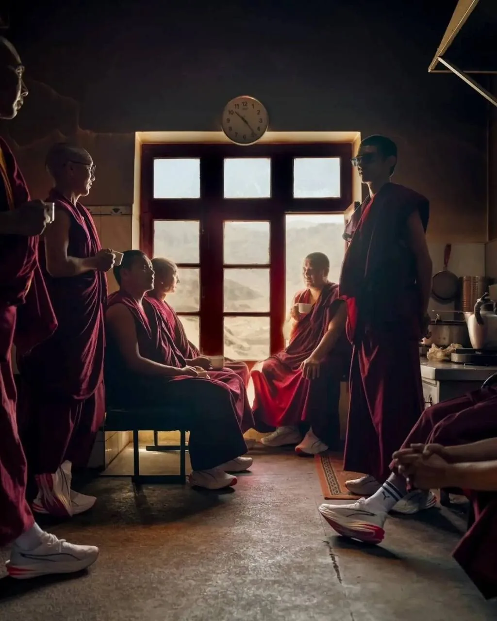 Монахи на чайной паузе у окна монастыря
